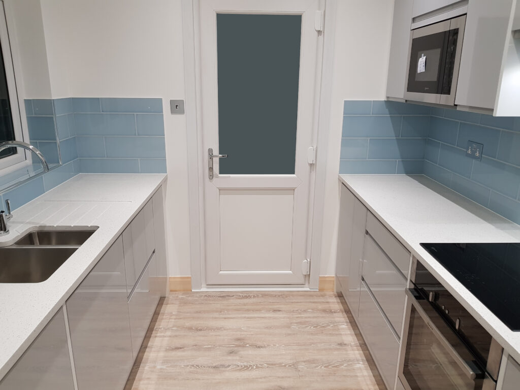 Professional kitchen installation in Mill Hill featuring a handleless kitchen and a corian worktop as the main focal points