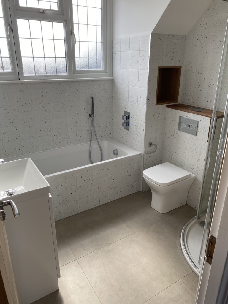Professional bathroom installation in Arkley featuring a speckle porcelain tiles and a back to wall toilet as the main focal points
