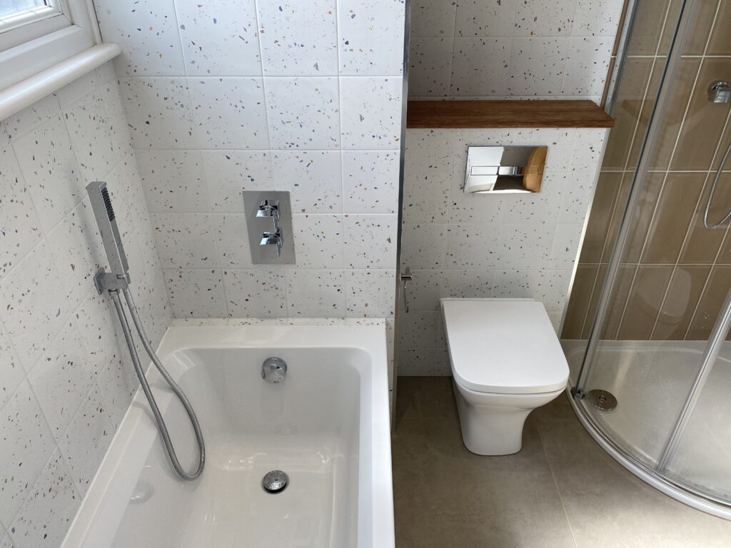 Professional bathroom installation in Arkley featuring a speckle porcelain tiles and a single ended bath as the main focal points