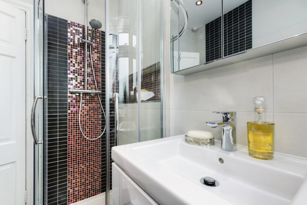Professional bathroom installation in Mill Hill featuring a chrome expose shower and a mosaic tiles as the main focal points