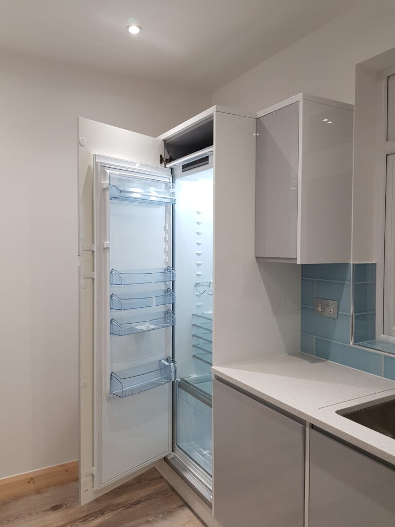 Professional kitchen installation in Mill Hill featuring an integrated fridge freezer and a handleless kitchen as the main focal points