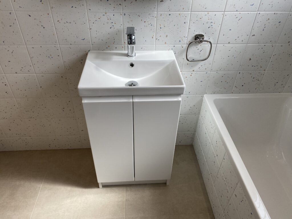 Professional bathroom installation in Arkley featuring a square basin and a speckle porcelain tile as the main focal points