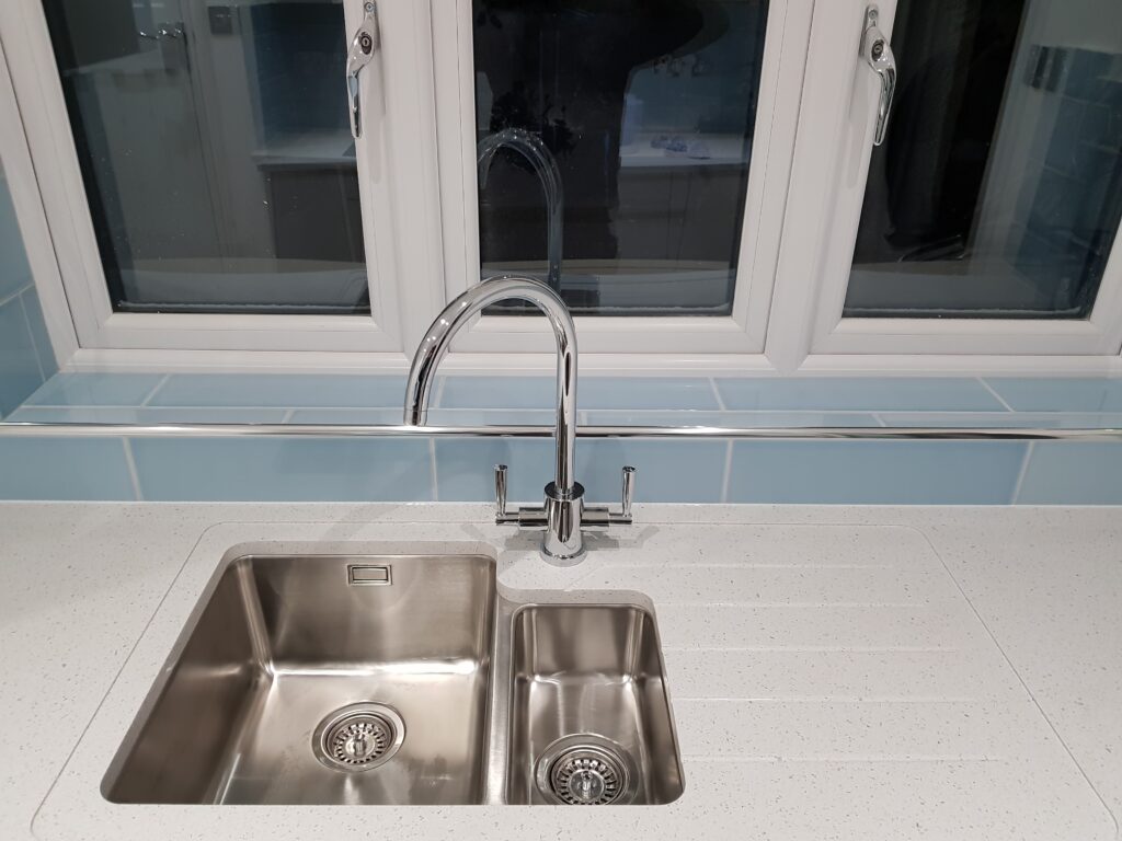 Professional kitchen installation in Mill Hill featuring a chrome kitchen tap and an under mount sink as the main focal points