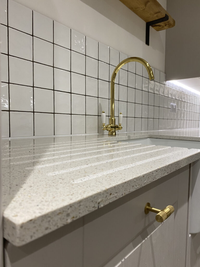 Professional kitchen installation in Totteridge featuring a gold kitchen tap and a quartz worktop as the main focal points