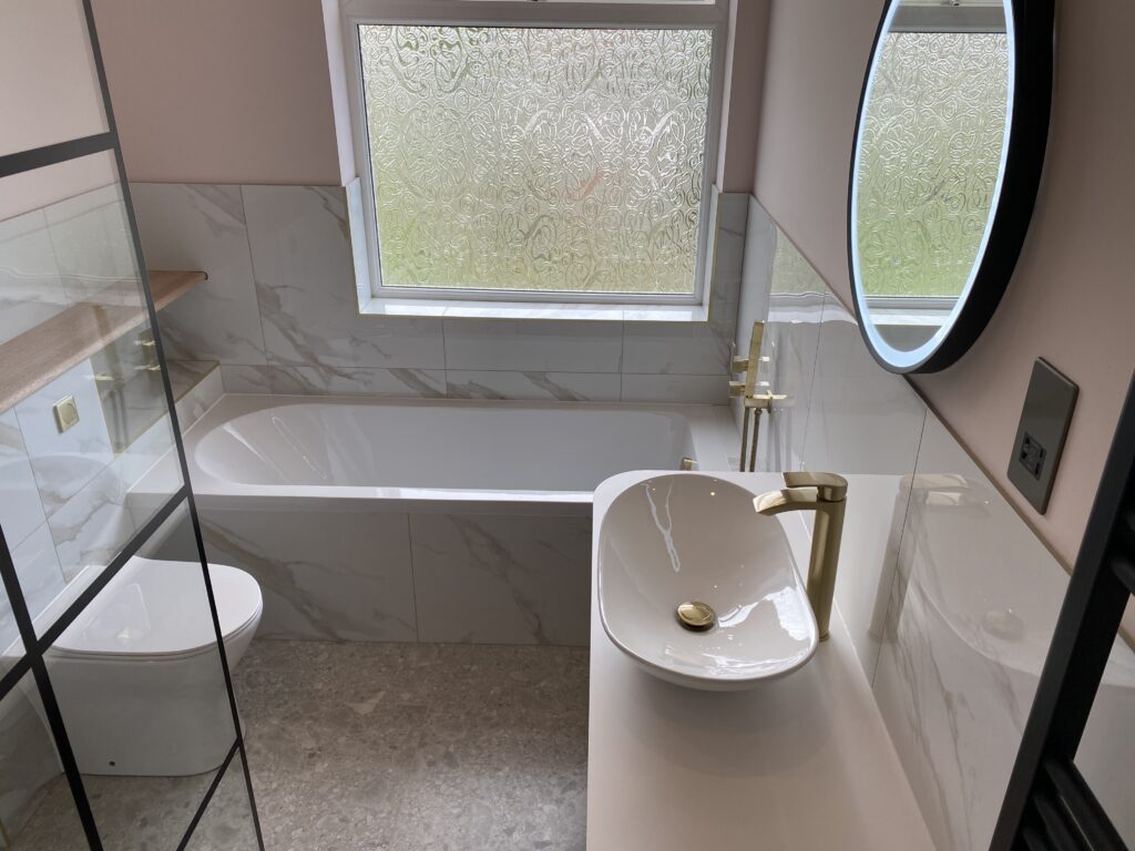 Professional bathroom installation in Hadley Wood featuring a round mirror and a oval vessel basin as the main focal points