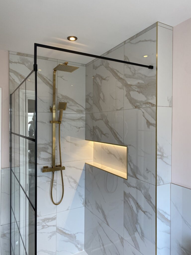 Professional bathroom installation in Hadley Wood featuring a marble tiles and a shower niche as the main focal points