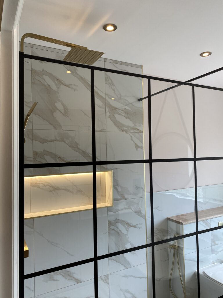 Professional bathroom installation in Hadley Wood featuring a black shower screen and a shower niche as the main focal points