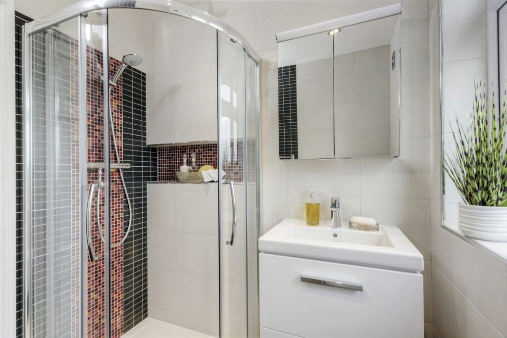 Professional bathroom installation in Mill Hill featuring a quadrant shower and a mirror cabinet as the main focal points