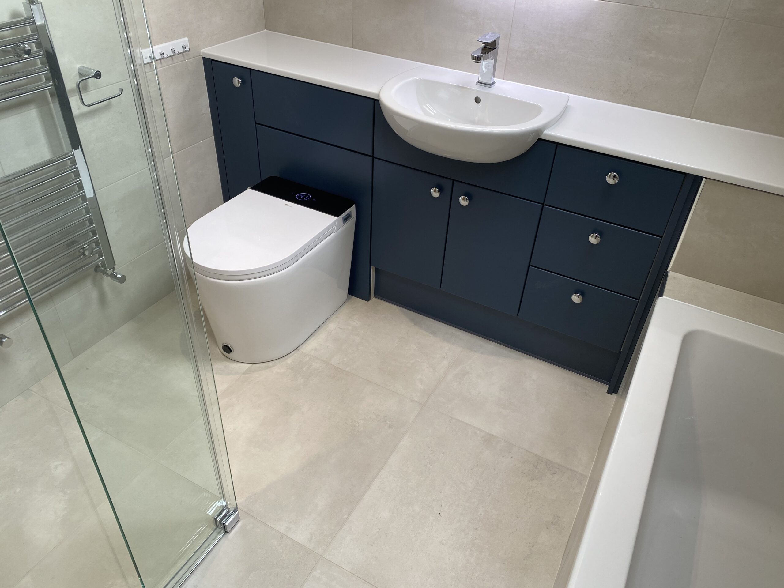 Professional wet room installation in Totteridge featuring a blue vanity unit and a smart toilet as the main focal points