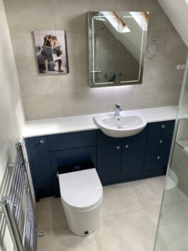 Professional wet room installation in Totteridge featuring a mirror cabinet and a smart toilet as the main focal points. The design is completed with a blue bathroom vanity and a porcelain tiles for a cohesive modern finish. Project completed by A Martens Kitchens & Bathrooms Ltd. For a free quote, visit https://amartens.co.uk to discuss your wet room renovation. Professional wet room installation in Totteridge featuring a mirror cabinet and a smart toilet as the main focal points