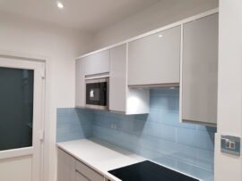 Professional kitchen installation in Mill Hill featuring a blue metro tiles and a build-in microwave as the main focal points. The design is completed with a handleless kitchen and a corian worktop for a cohesive modern finish. Project completed by A Martens Kitchens & Bathrooms Ltd. For a free quote, visit https://amartens.co.uk to discuss your kitchen renovation. Professional kitchen installation in Mill Hill featuring a blue metro tiles and a build-in microwave as the main focal points