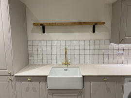 Professional kitchen installation in Totteridge featuring a wood shelves and a belfast sink as the main focal points. The design is completed with a square tiles and a gold kitchen tap for a cohesive modern finish. Project completed by A Martens Kitchens & Bathrooms Ltd. For a free quote, visit https://amartens.co.uk to discuss your kitchen renovation. Professional kitchen installation in Totteridge featuring a wood shelves and a belfast sink as the main focal points.