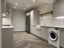 Professional kitchen installation in Totteridge featuring a luxury kitchen and a washing machine as the main focal points. The design is completed with a belfast sink and a wood porcelain tiles for a cohesive modern finish. Project completed by A Martens Kitchens & Bathrooms Ltd. For a free quote, visit https://amartens.co.uk to discuss your kitchen renovation. Professional kitchen installation in Totteridge featuring a luxury kitchen and a washing machine as the main focal points