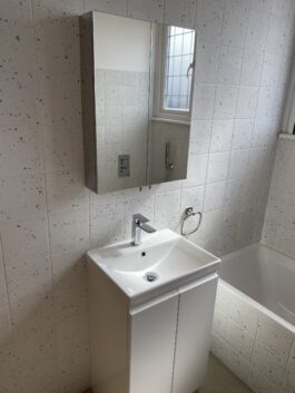 Professional bathroom installation in Arkley featuring a mirror cabinet and a square basin as the main focal points. The design is completed with a speckle porcelain tiles and a white vanity unit for a cohesive modern finish. Project completed by A Martens Kitchens & Bathrooms Ltd. For a free quote, visit https://amartens.co.uk to discuss your bathroom renovation. Professional bathroom installation in Arkley featuring a mirror cabinet and a square basin as the main focal points