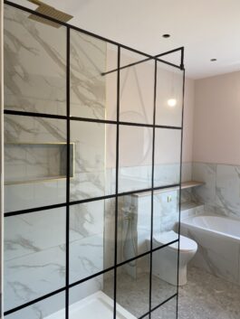 Professional bathroom installation in Hadley Wood featuring a black shower screen and a marble tiles as the main focal points. The design is completed with a shower niche for a cohesive modern finish. Project completed by A Martens Kitchens & Bathrooms Ltd. For a free quote, visit https://amartens.co.uk to discuss your bathroom renovation. Professional bathroom installation in Hadley Wood featuring a black shower screen and a marble tiles as the main focal points