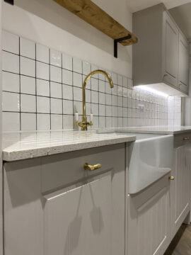 Professional kitchen installation in Totteridge featuring a quartz worktop and a belfast sink as the main focal points. The design is completed with a gold kitchen tap and a ceramic tiles for a cohesive modern finish. Project completed by A Martens Kitchens & Bathrooms Ltd. For a free quote, visit https://amartens.co.uk to discuss your kitchen renovation. Professional kitchen installation in Totteridge featuring a quartz worktop and a belfast sink as the main focal points