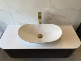 Professional bathroom installation in Hadley Wood featuring a gold basin tap and a oval vessel basin as the main focal points. The design is completed with a quartz worktop and a black vanity unit for a cohesive modern finish. Project completed by A Martens Kitchens & Bathrooms Ltd. For a free quote, visit https://amartens.co.uk to discuss your bathroom renovation. Professional bathroom installation in Hadley Wood featuring a gold basin tap and a oval vessel basin as the main focal points