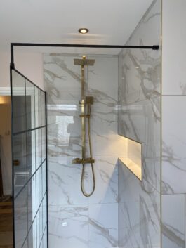Professional bathroom installation in Hadley Wood featuring a gold expose shower and a marble tiles as the main focal points. The design is completed with a shower niche and a black shower screen for a cohesive modern finish. Project completed by A Martens Kitchens & Bathrooms Ltd. For a free quote, visit https://amartens.co.uk to discuss your bathroom renovation. Professional bathroom installation in Hadley Wood featuring a gold expose shower and a marble tiles as the main focal points