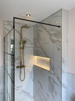 Professional bathroom installation in Hadley Wood featuring a marble tiles and a shower niche as the main focal points. The design is completed with a gold expose shower and a black shower screen for a cohesive modern finish. Project completed by A Martens Kitchens & Bathrooms Ltd. For a free quote, visit https://amartens.co.uk to discuss your bathroom renovation. Professional bathroom installation in Hadley Wood featuring a marble tiles and a shower niche as the main focal points